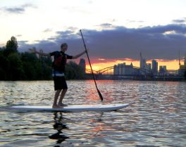 Stand Up Paddler vor Frankfurter Skyline im Sonnenuntergang